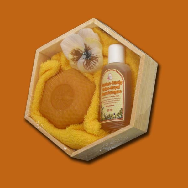 Das Geschenk „Holzwabe Honig“ ist ein schönes Set aus Akazienhonig-Shampoo, Honig-Milch-Wabenseife und einem gelben Waschhandschuh. Ideal als hochwertiges Geschenk für Wellness-Freunde.