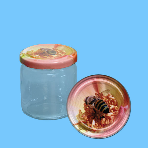 Das neutrale 500 g Honigglas mit einem runden TO-Metall-Deckel zeigt eine Biene auf einer rosa Blüte. Mit einem Durchmesser von 82 mm Ø eignet es sich perfekt für die Präsentation von Honig und verleiht der Verpackung einen zarten, floralen Touch.
