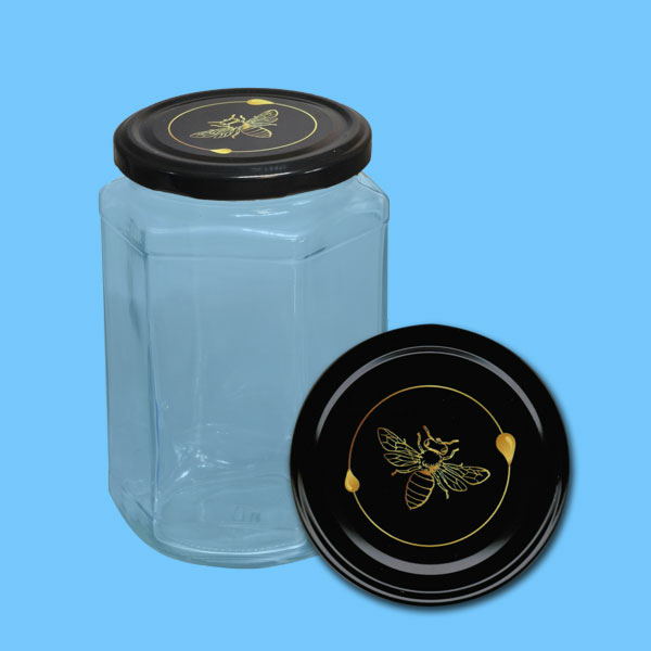 Dieses sechseckige Honigglas mit einem Fassungsvermögen von 1000 g wird durch ein charmantes Motiv einer Wabe mit einer gelben Blume und einer Biene auf dem TO-Deckel veredelt. Es ist ideal für die Präsentation von Honig oder als stilvolles Geschenk. Das Glas besticht durch seine klare Form und die Detailtreue des Designs, das die Schönheit der Natur widerspiegelt.