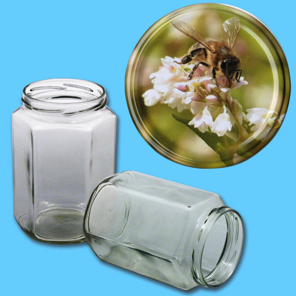Das 1000 g Honigglas im sechseckigen Design wird mit einem TO-Deckel geliefert, auf dem eine Biene auf einer Buchweizenblüte abgebildet ist. Diese naturgetreue Darstellung bringt den Imkergedanken zum Leben und macht das Glas zu einem einzigartigen Stück für die Präsentation von Honig.