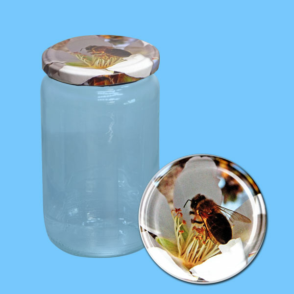 Das 1000 g Honigglas bietet Platz für eine großzügige Menge Honig und ist mit einem dekorativen TO-Deckel versehen, der eine Biene auf einer Apfelblüte zeigt. Mit einem Durchmesser von 82 mm ist es sowohl funktional als auch ästhetisch ansprechend.