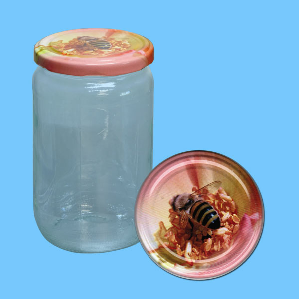 Ein rundes Honigglas mit TO-Deckel, das eine Biene auf einer rosa Blüte zeigt. Mit einem Durchmesser von 82 mm bietet dieses Glas 1000 g Honig Platz und überzeugt durch seine harmonische Gestaltung. Ideal für die Präsentation von Honig in hochwertigen Verpackungen.