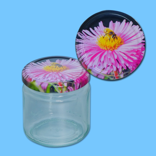 Das 250 g Honigglas im runden Design mit einem TO-Metall-Deckel, der eine Biene auf einer gelben Blume zeigt, ist eine schöne Verpackung für Honig. Mit einem Durchmesser von 66 mm wird es im Karton mit 600 Gläsern geliefert. Ideal für Imker, die ein ansprechendes Design suchen.